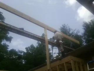 Carpenter setting a ridge beam over a new addition frame — Ice Dam Removal by Roofing Brothers in Williams Bay
