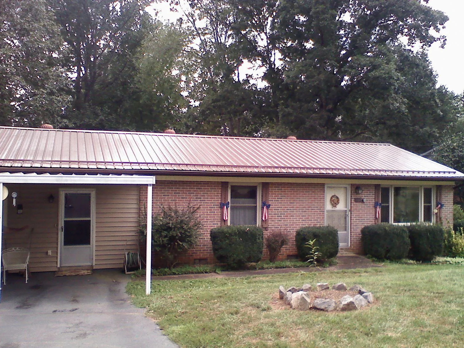Bronze metal roof and carport on a brick ranch home — Roof Repair work by our crew in Williams Bay